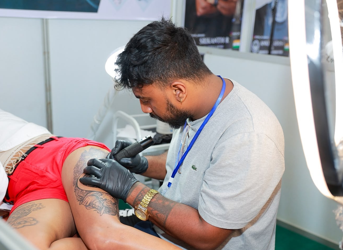 Divine Tattoo artist tattooing a client's arm